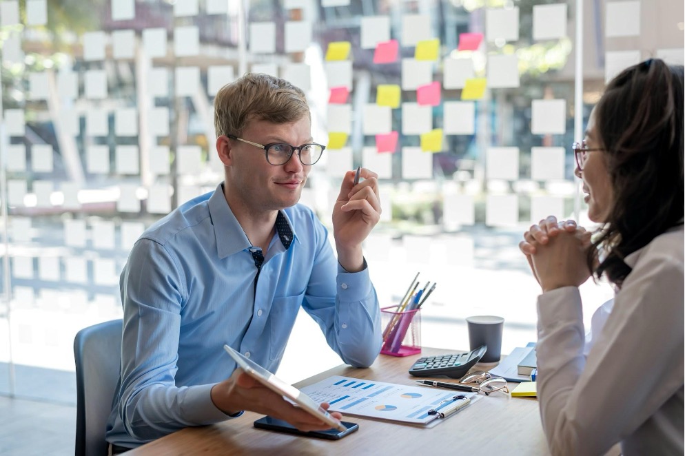 A merchant services sales agent talks to a small business owner in her office.